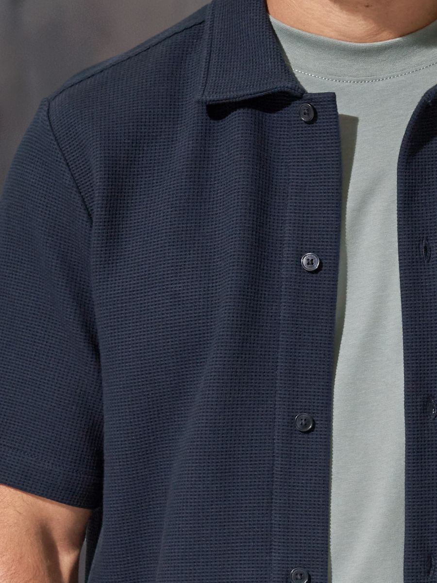 Marineblaues Waffelstrick-Poloshirt mit Knopfleiste