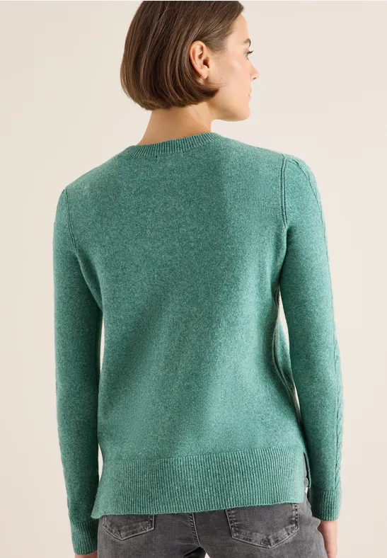 Grüner Strickpullover mit Zopfärmeln