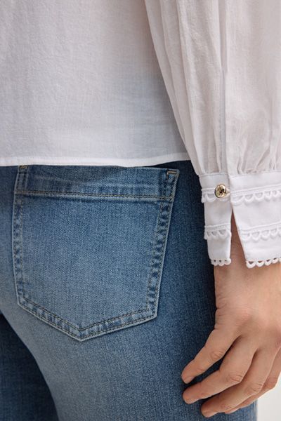 Feminine weiße Baumwollbluse mit plissierter Vorderseite und Spitzendetails