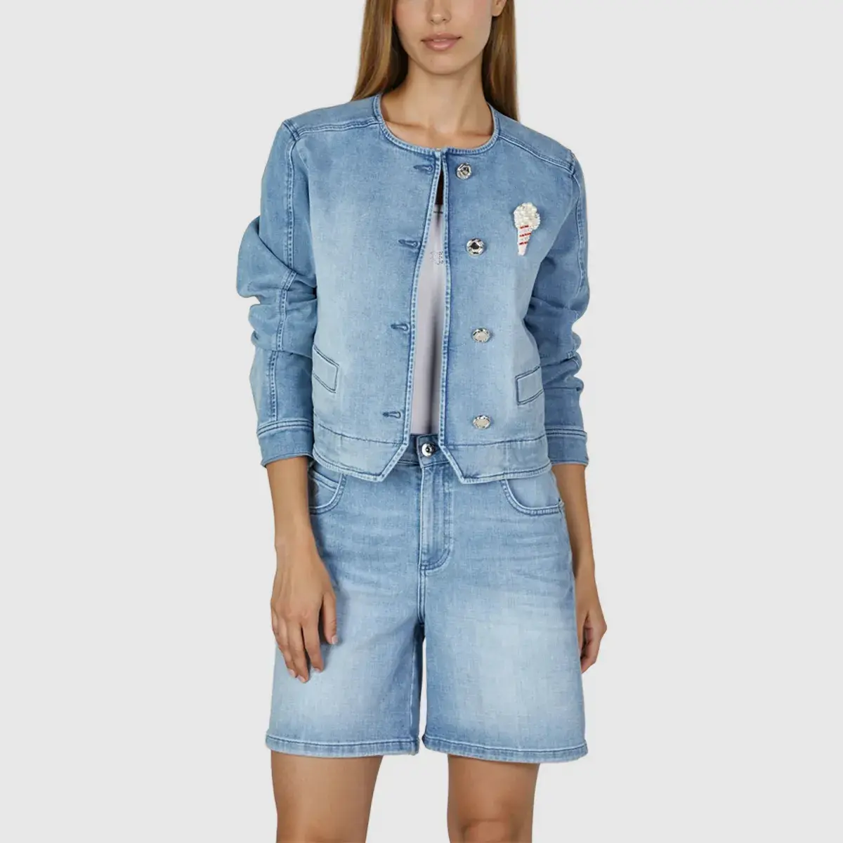 Kragenlose Kurzjacke aus Denim mit Brosche